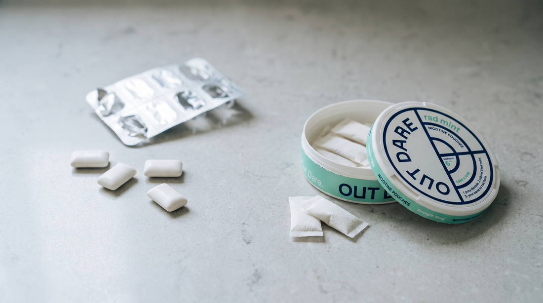 Nicotine gum tablets scattered beside an open nicotine pouch can on a grey stone worktop