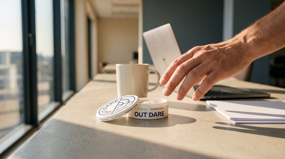 Open nicotine pouch can on a European office desk with an adult hand nearby