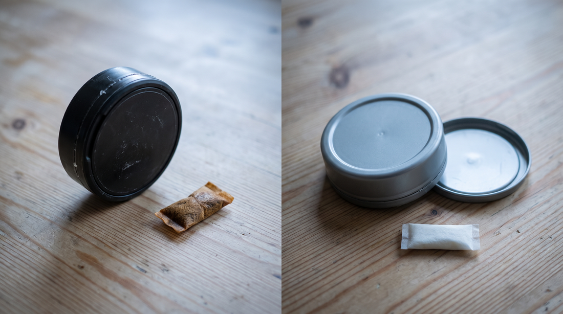 Used brown snus pouch beside a worn can, with a clean nicotine pouch can upturned on a pine surface