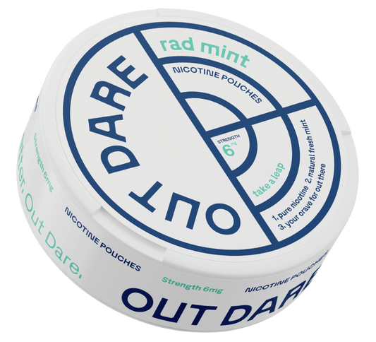 OutDare nicotine pouches can on a worn oak table beside a blurred mug in an Austrian morning interior