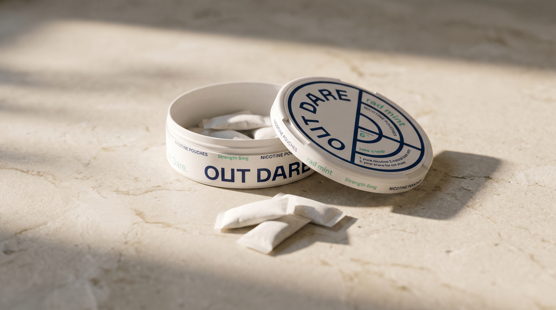 An open nicotine pouch can with white pouches on a pale stone surface
