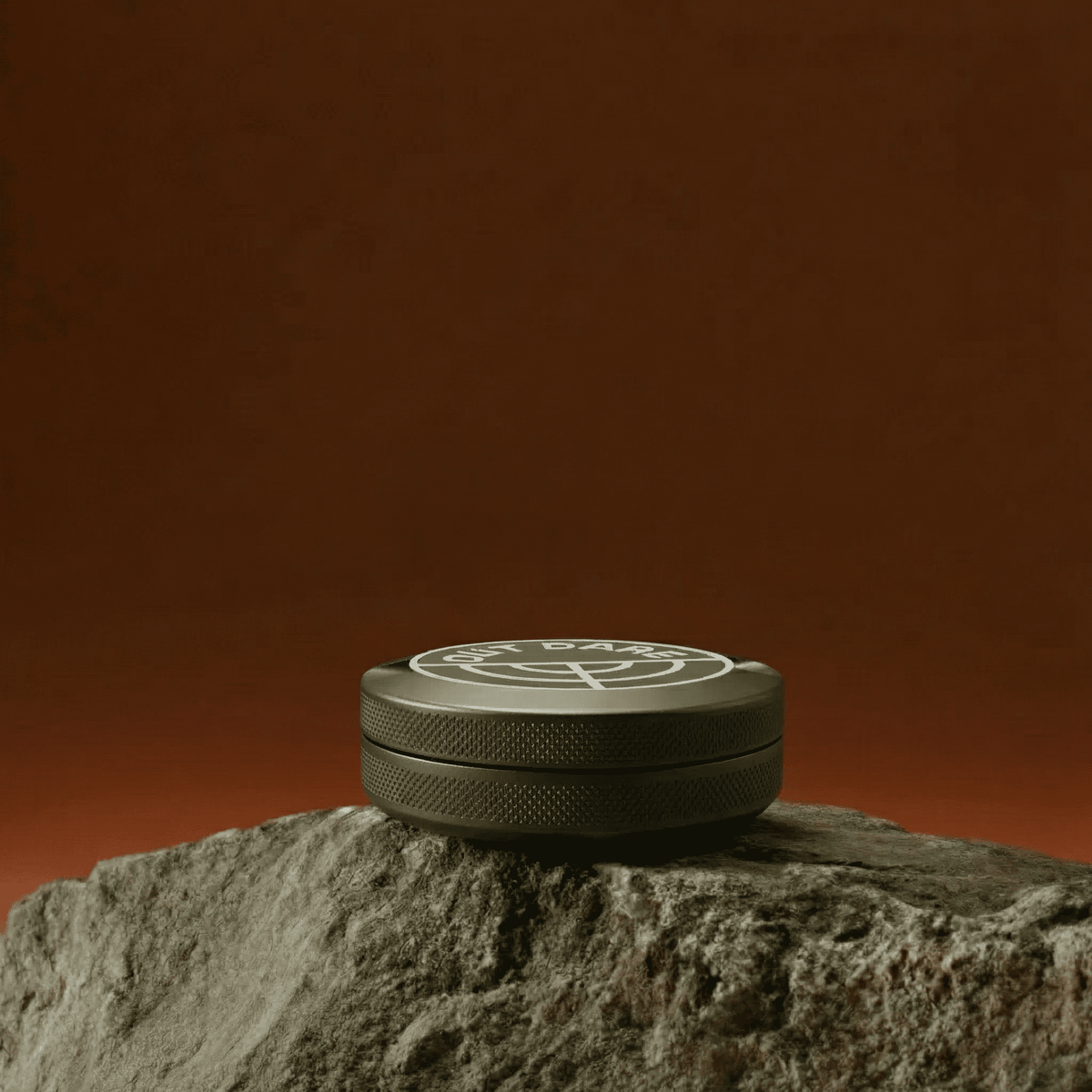 Green OutDare metal can lying flat on a rock