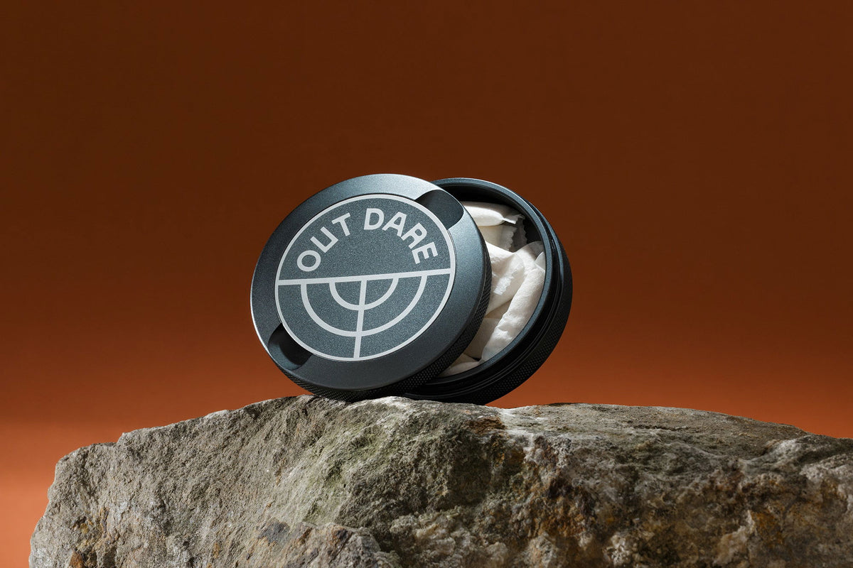 Silver OutDare metal can with pouches, on a rock