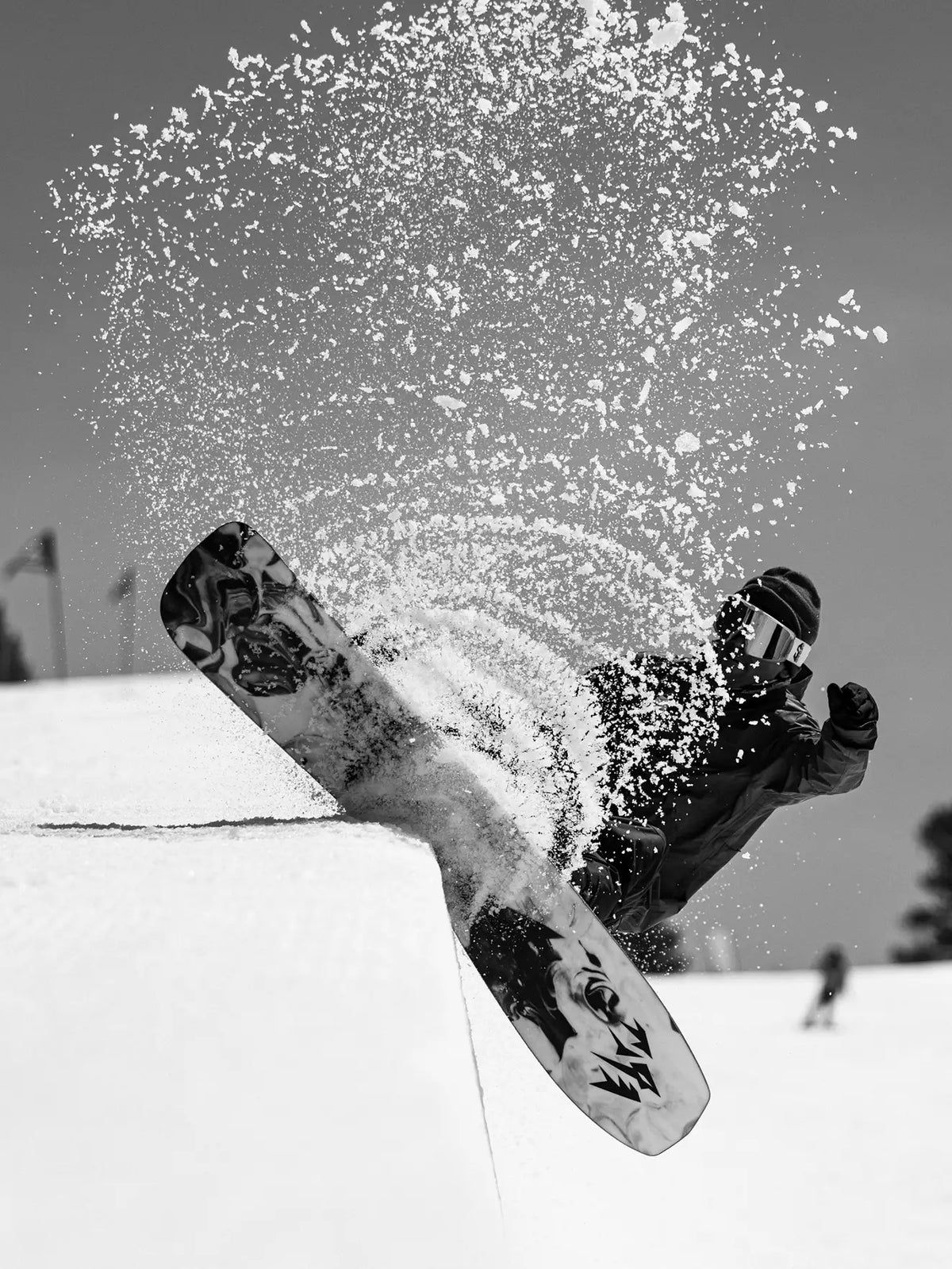 Snowboarder spraying snow on a half-pipe